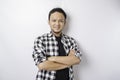 Portrait of a confident smiling Asian man wearing tartan shirt standing with arms folded and looking at the camera isolated over Royalty Free Stock Photo