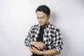 Portrait of a confident smiling Asian man wearing tartan shirt standing with arms folded and looking at the camera isolated over Royalty Free Stock Photo