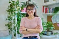 Portrait of confident smiling middle-aged woman with crossed arms at home Royalty Free Stock Photo