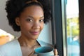Portrait of confident smiling young african american afro woman holding coffee cup at home Royalty Free Stock Photo