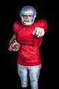 Portrait of confident sportsman pointing while holding American football