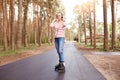 Portrait of confident sporty energetic young female listening to music, putting on headphones, having roller blades on legs, Royalty Free Stock Photo