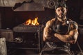 Portrait of confident strong young metalworker in black apron Royalty Free Stock Photo