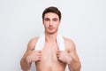 Portrait of confident stunning dreamy athletic sporty guy holding towel on neck, he is going to take a morning shower, isolated o Royalty Free Stock Photo