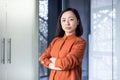 Portrait of a confident and successful business woman of Asian origin standing in the office with her arms crossed on Royalty Free Stock Photo