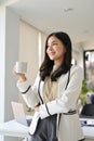 Portrait of a confident Asian businesswoman daydreaming while sipping coffee Royalty Free Stock Photo