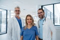 Portrait of confident three doctors standing in Hospital corridor. Medical team wearing white coat, stethoscope around Royalty Free Stock Photo
