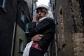 Portrait of a confident and tough alternative woman model posing in a narrow street.