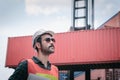 Portrait of Confident Transport Engineer Man in Safety Equipment Standing in Container Ship Yard. Transportation Engineering