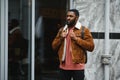 portrait of confident trendy serious african guy in stylish outfit, young afro american male posing at camera, looking Royalty Free Stock Photo