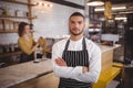 Portrait of confident waiter standing with arms crossed at coffee shop Royalty Free Stock Photo