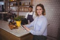 Portrait of confident waitress using digital tablet while standing at counter Royalty Free Stock Photo