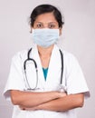 Portrait of Confident woman or female doctor wearing medical face mask standing with crossed arms on isolated background Royalty Free Stock Photo