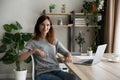 Portrait of confident woman in headphones sitting at work desk