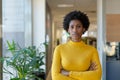 Portrait of confident young african american businesswoman with arms crossed at modern workplace Royalty Free Stock Photo