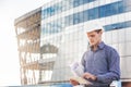 Portrait of confident young architect or chief engineer uses digital tablet at the construction site