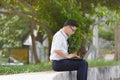 Portrait of confident young Asian business man working with laptop at public park. Royalty Free Stock Photo