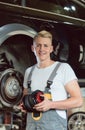 Portrait of a confident young auto mechanic holding a new air suspension system Royalty Free Stock Photo