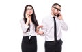 Portrait of a confident young business couple talking on mobile phone isolated over white background Royalty Free Stock Photo