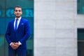 Portrait of confident young businessman in blue suit standing on Royalty Free Stock Photo