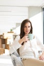 Portrait of confident young businesswoman drinking coffee in new office Royalty Free Stock Photo