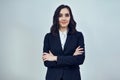 portrait of a confident young businesswoman entrepreneur arms crossed wearing black jacket on a white background Royalty Free Stock Photo