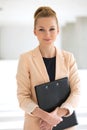 Portrait of confident young businesswoman holding file in office Royalty Free Stock Photo