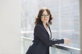 Portrait of confident young businesswoman leaning on railing in office Royalty Free Stock Photo