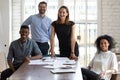 Joyful millennial diverse professionals gathered near table. Royalty Free Stock Photo