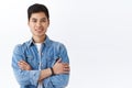 Portrait of confident young hipster male, asian guy in denim jacket talking to friends in campus, cross hands over chest Royalty Free Stock Photo