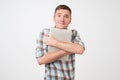 Portrait of confident young man laptop standing against blue wall Royalty Free Stock Photo