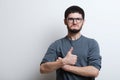 Portrait of confident young man showing thumbs up, over white background. Wearing glasses and grey sweater Royalty Free Stock Photo