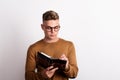 Portrait of a confident young man in a studio, making notes in a personal diary. Copy space.