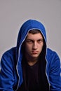 Portrait of confident young man wearing blue hooded sweatshirt