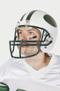 Portrait of confident young man wearing football uniform against gray background