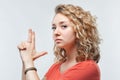 Portrait of Confident young woman holding hands like gun. Studio shot, white background Royalty Free Stock Photo