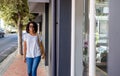 Confident young woman walking along a city sidewalk Royalty Free Stock Photo