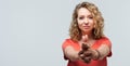 Portrait of Confident young woman holding hands like gun. Studio shot, white background. Copy space Royalty Free Stock Photo