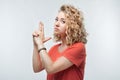 Portrait of Confident young woman holding hands like gun. Studio shot, white background Royalty Free Stock Photo