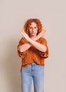 Portrait of confident young woman showing rejecting sign with crossed hands over white background Royalty Free Stock Photo