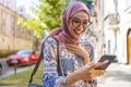 Portrait of confident young woman wearing hijab standing with mobile phone Royalty Free Stock Photo