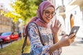 Portrait of confident young woman wearing hijab standing with mobile phone Royalty Free Stock Photo