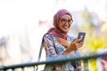 Portrait of confident young woman wearing hijab standing with mobile phone Royalty Free Stock Photo