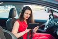 Portrait of confused and anxious business lady, caucasian young woman driver in red summer suit setting up the route on a