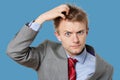 Portrait of confused businessman scratching head