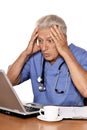 Portrait of confused doctor with a laptop on white background