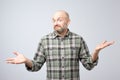 Portrait of confused mature man d standing over white background gesturing with hands. Royalty Free Stock Photo