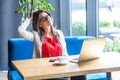 Portrait of confused query beautiful stylish brunette young woman in glasses sitting, scratching her head and thinking about new Royalty Free Stock Photo