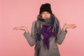 Portrait of confused uncertain woman wearing hat and scarf in autumn, raising hands gesturing I don`t know