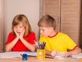 Portrait confused, unhappy, stressed tired, frightened girl doing homework with brother. School and education concept. Facial exp Royalty Free Stock Photo